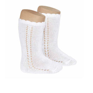 Calcetín alto en color blanco con calado lateral, de la marca española Condor. Tiene un toque elegante y cómodo para cumpleaños, bautizos y días especiales. Transpirables, suaves y pensados para acompañar con estilo cada paso.